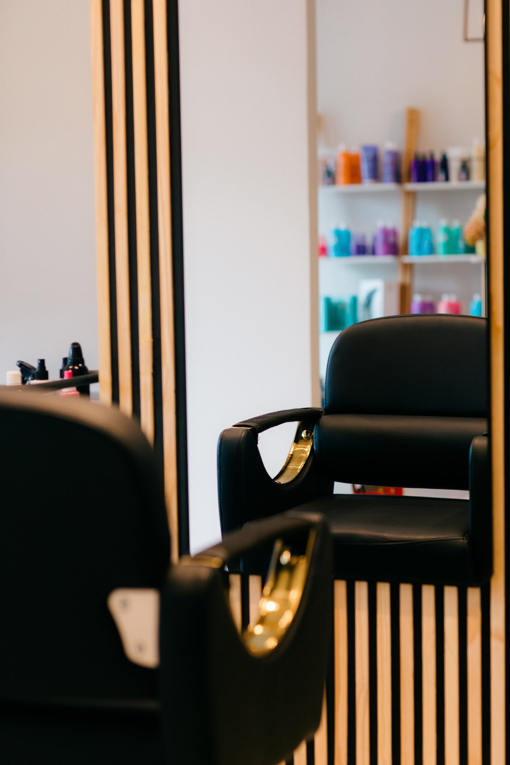 black leahter stylist chair in front of mirror